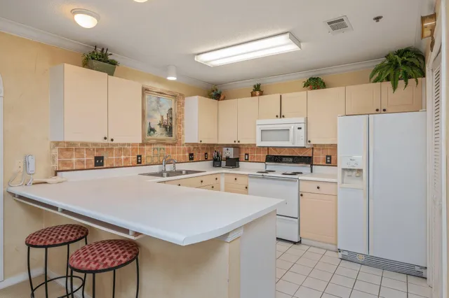 a kitchen with stainless steel appliances a refrigerator sink and white cabinets