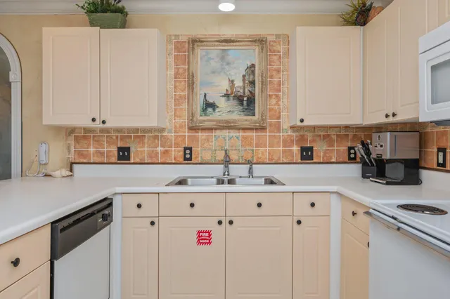 a kitchen with granite countertop a sink a stove and cabinets