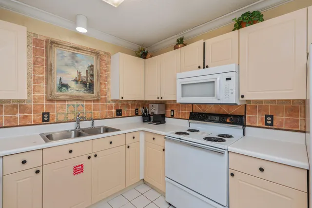 a kitchen with cabinets appliances a sink and a counter top space