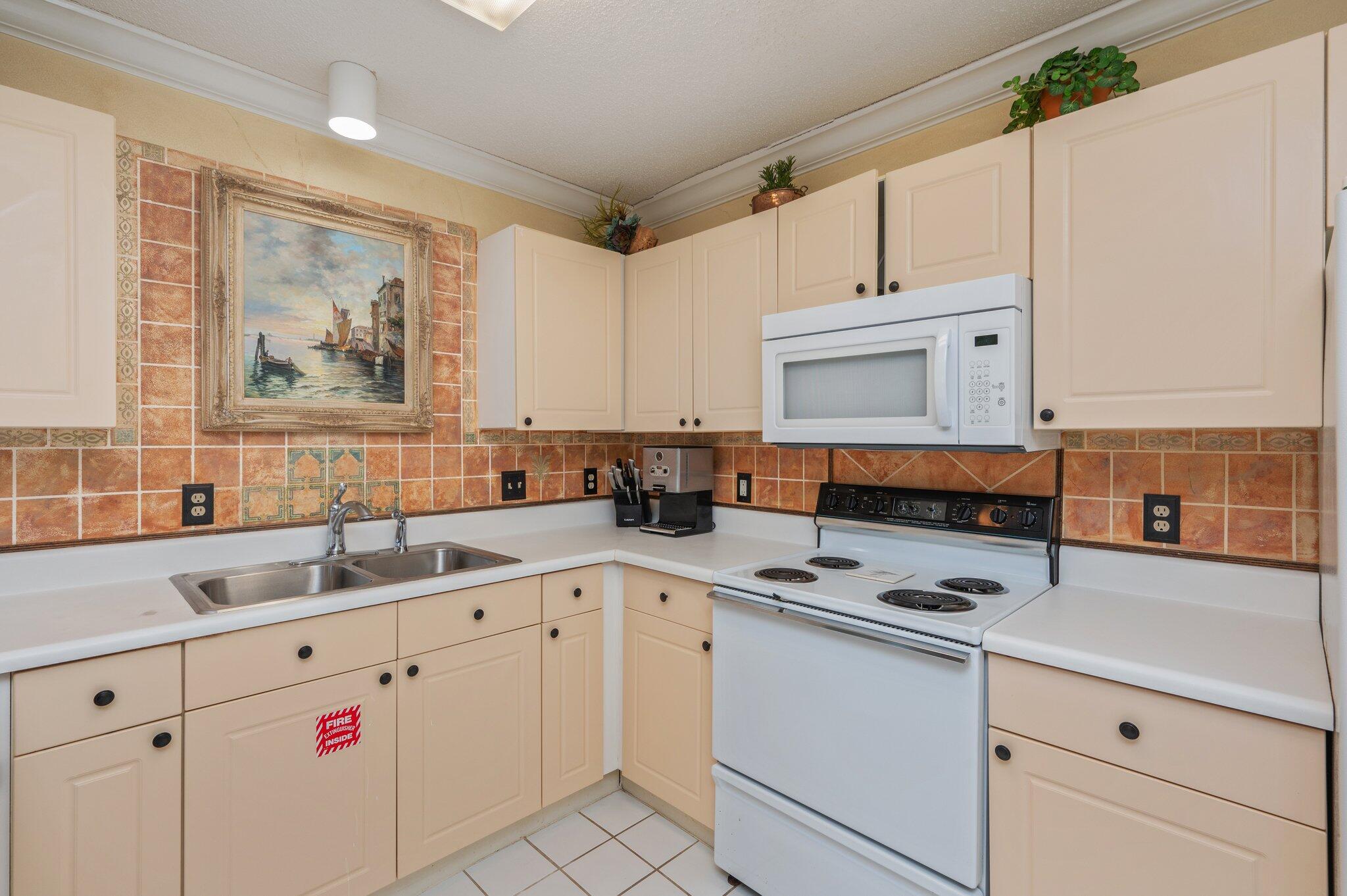 144 Spires Lane, Unit 403 Santa Rosa Beach, FL 32459 - Photo 14 of 38 a kitchen with cabinets appliances a sink and a counter top space