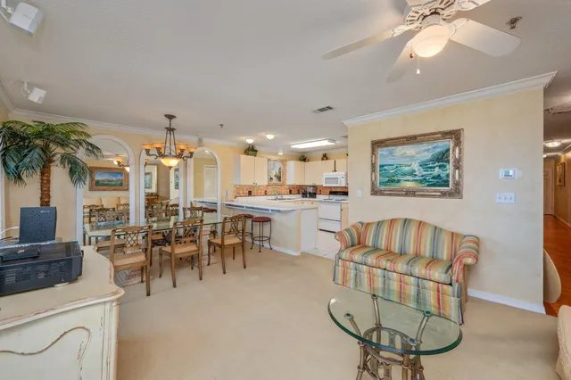 a living room with furniture a dining table and a chandelier