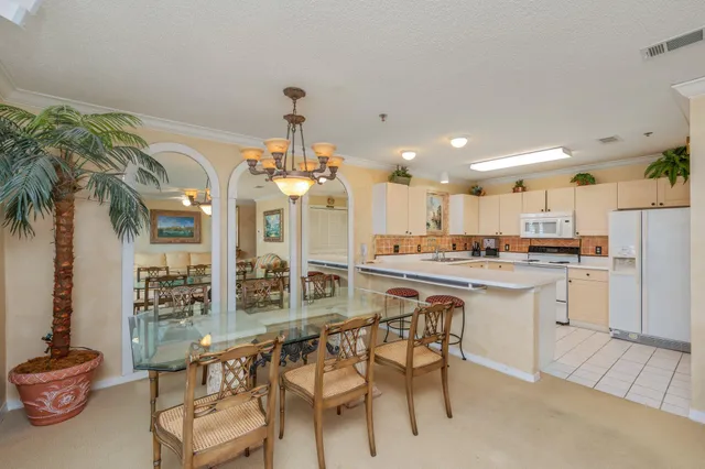 a kitchen with stainless steel appliances kitchen island granite countertop a table and chairs in it