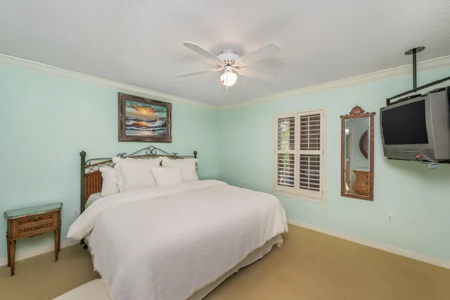 a bedroom with a bed a flat screen tv and dresser
