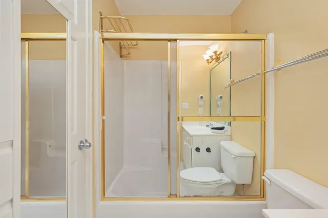 a bathroom with a granite countertop shower toilet and sink