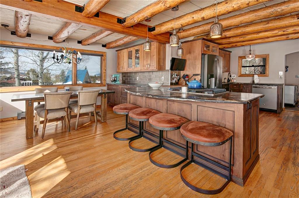 39 D Road Silverthorne, CO 80498 - Photo 11 of 35 a dining hall with stainless steel appliances granite countertop a stove a sink a dining table and chairs with wooden floor