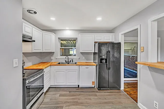 a kitchen with stainless steel appliances granite countertop a refrigerator and a stove top oven