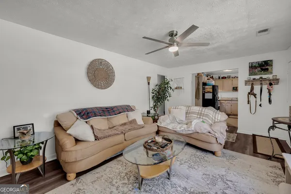 a living room with furniture a rug potted plant and a window