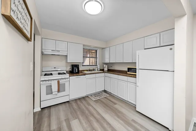 a kitchen with granite countertop white cabinets and white appliances
