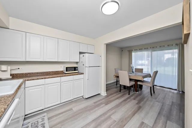 a kitchen with stainless steel appliances granite countertop a stove a sink dishwasher and a microwave with wooden floor