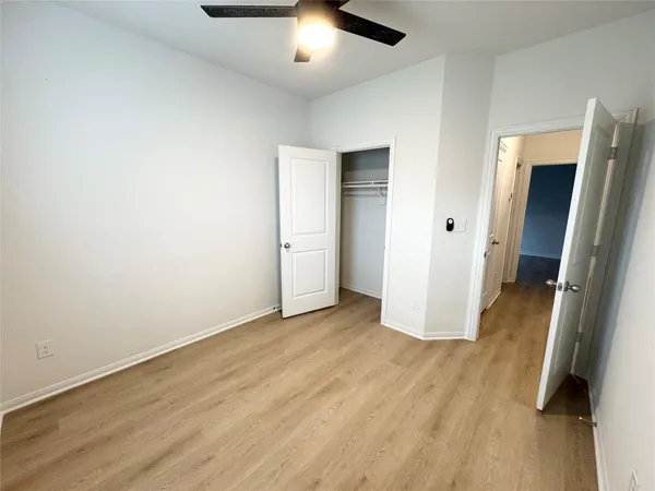 an empty room with wooden floor and cabinet