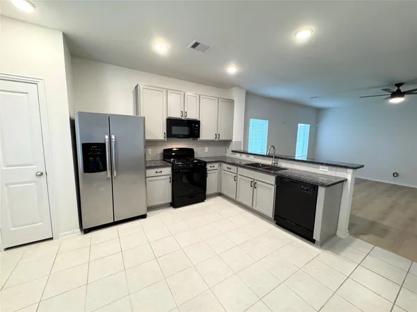 an empty room with wooden floor and ceiling fan
