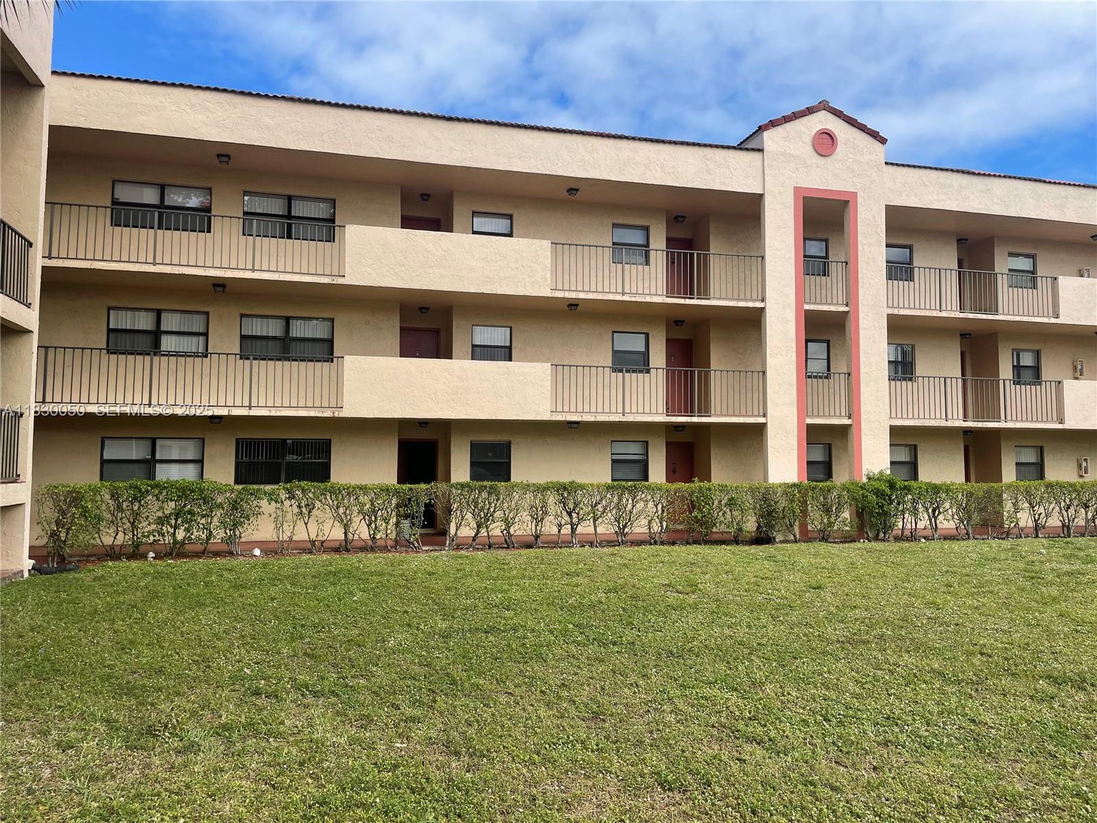 3399 Foxcroft Road, Unit 315 Miramar, FL 33025 - Photo 1 of 9 a front view of building with yard