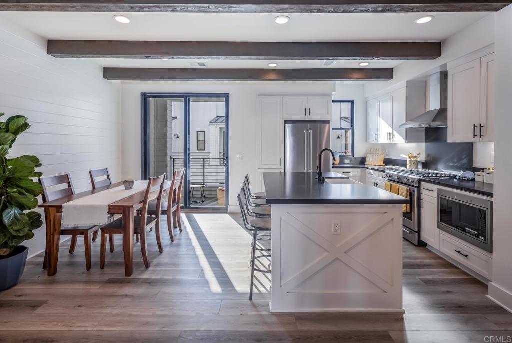 a kitchen with stainless steel appliances granite countertop a stove a sink a microwave dining table and chairs