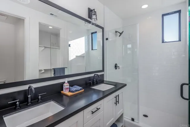 a bathroom with a sink double vanity granite and shower