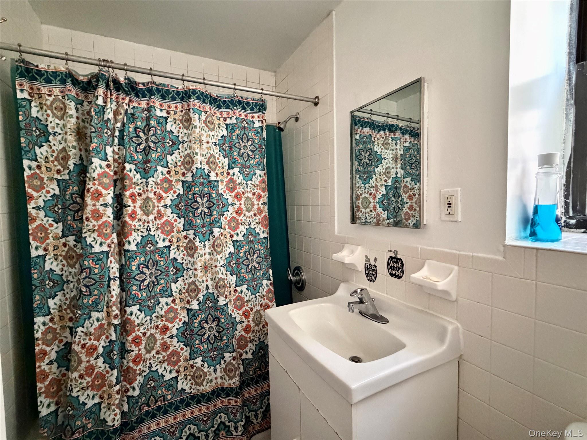 518 West 135th Street, Unit 5C Manhattan, NY 10031 - Photo 6 of 10 a bathroom with a sink and a shower curtain