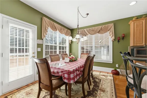 a dining room with furniture a chandelier and wooden floor