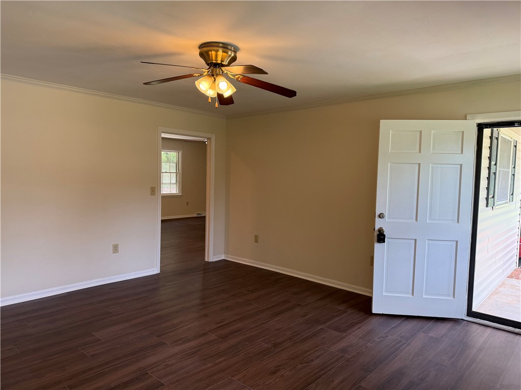 1507 East Calhoun Street Anderson, SC 29621 - Photo 4 of 18 Rich wood flooring and a classic ceiling fan elevate this inviting living space.