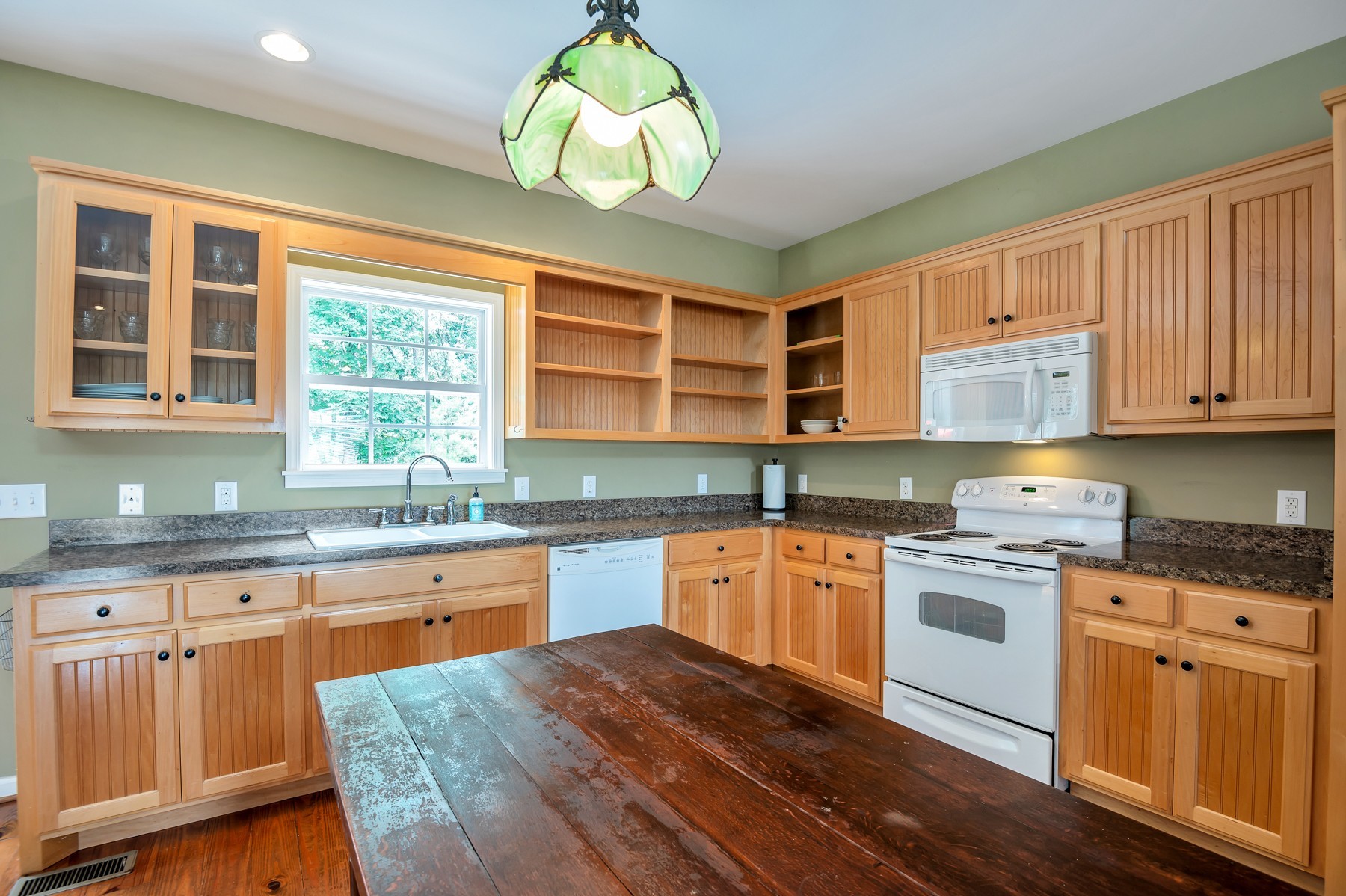 4949 Homer Worsham Road Springfield, TN 37172 - Photo 20 of 33 a kitchen with stainless steel appliances granite countertop wooden cabinets a stove a sink a dining table and chair