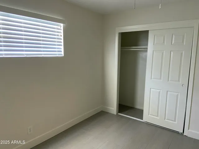 an empty room with windows and closet
