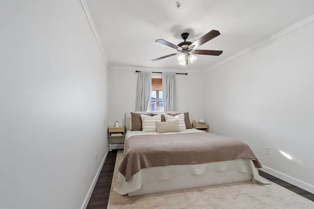 a bedroom with a bed and a ceiling fan