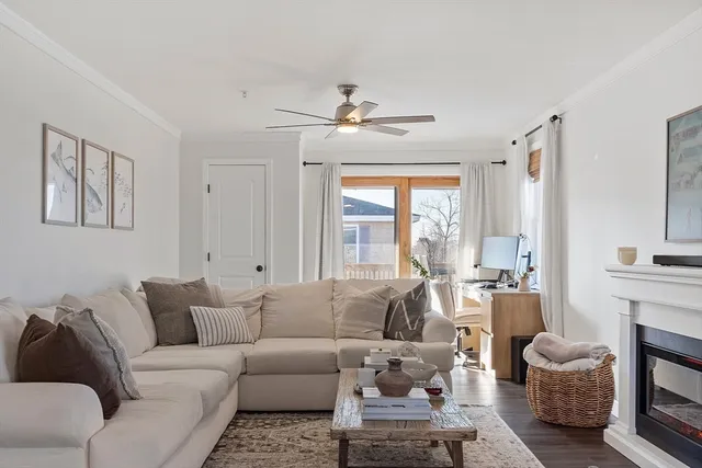 a living room with furniture a fireplace and a large window