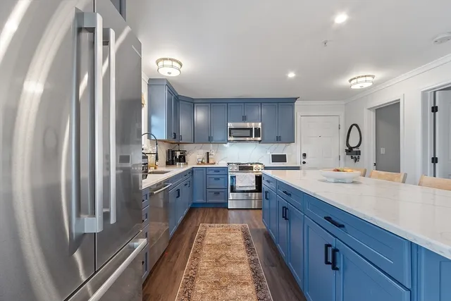 a large kitchen with stainless steel appliances sink a microwave and cabinets