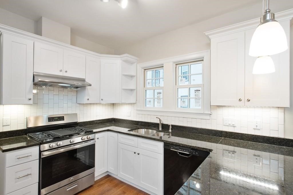 101 Lanark Road, Unit 1 Boston, MA 02135 - Photo 1 of 1 a kitchen with granite countertop white cabinets stainless steel appliances a sink and a window