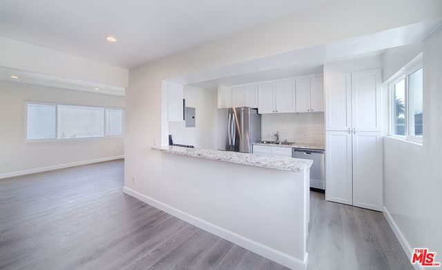 a kitchen with stainless steel appliances a sink and a refrigerator