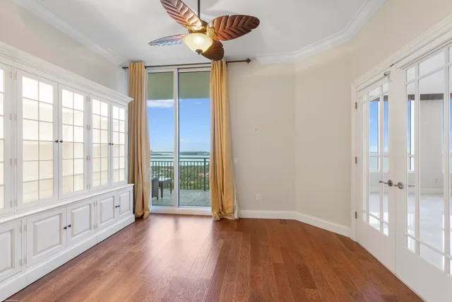 a bedroom with a large bed and a large window with the potted plant