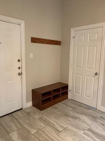 a view of an empty room with wooden cabinet