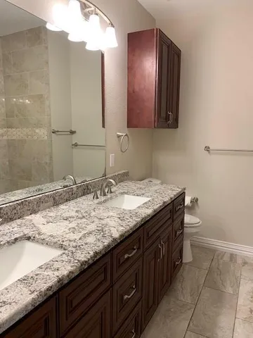 a bathroom with a granite countertop sink and a mirror