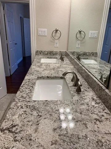 a bathroom with a granite countertop sink and a mirror