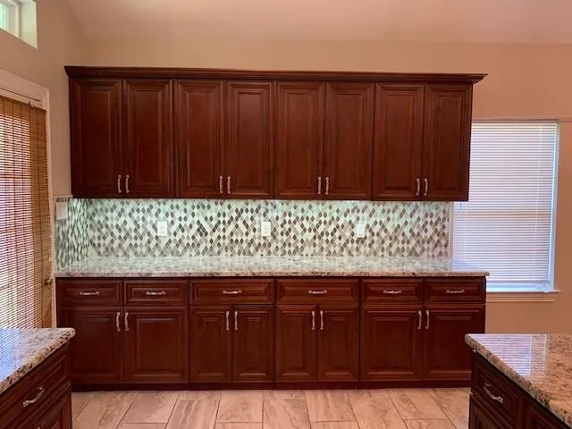 a kitchen with granite countertop wooden cabinets