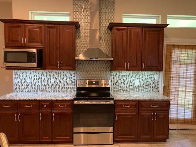 a kitchen with granite countertop wooden cabinets and stainless steel appliances