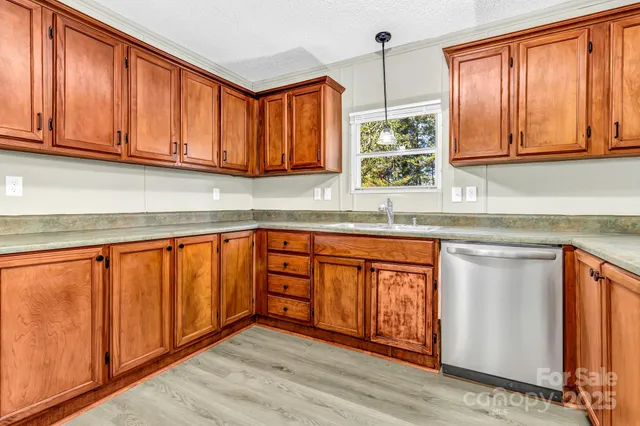 a kitchen with stainless steel appliances granite countertop wooden cabinets a sink and a window