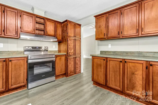 a kitchen with granite countertop wooden cabinets stainless steel appliances and a sink