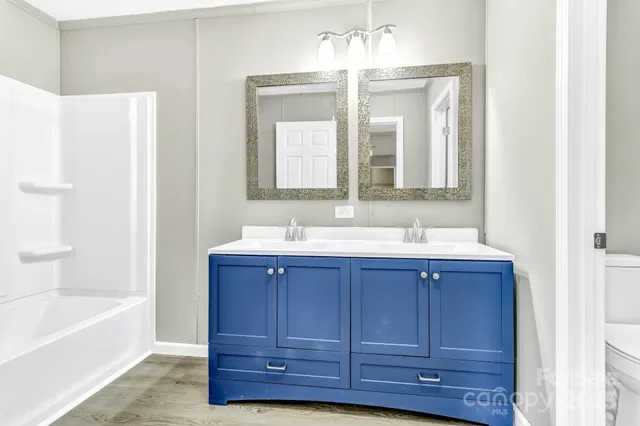 a bathroom with a tub sink and mirror