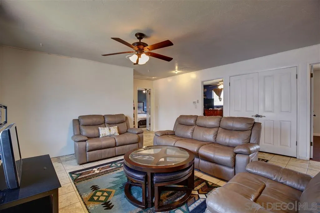 14558 Fruitvale Road Valley Center, CA 92082 - Photo 3 of 24 a living room with furniture a ceiling fan and a rug
