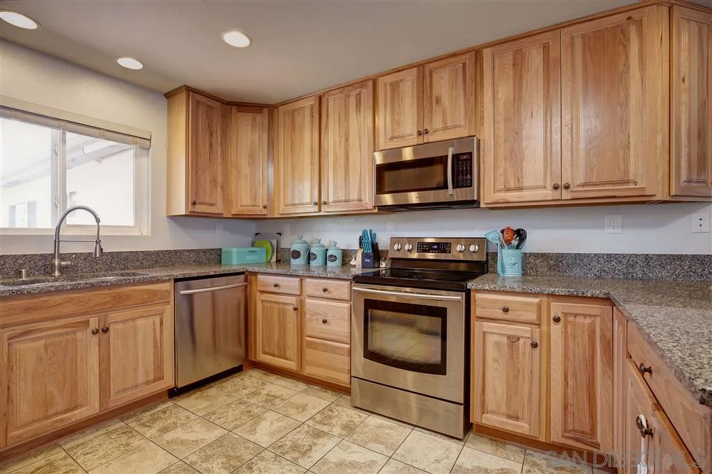 14558 Fruitvale Road Valley Center, CA 92082 - Photo 5 of 24 a kitchen with granite countertop a stove sink and cabinets