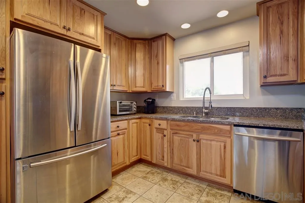 14558 Fruitvale Road Valley Center, CA 92082 - Photo 6 of 24 a kitchen with granite countertop stainless steel appliances a refrigerator sink and cabinets