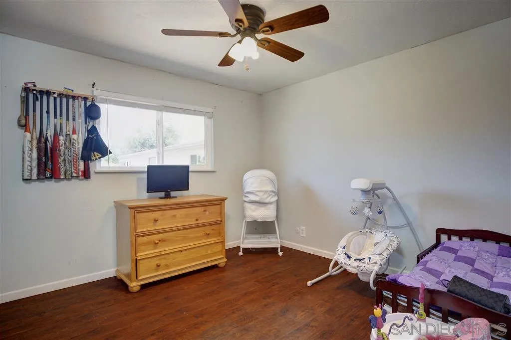 14558 Fruitvale Road Valley Center, CA 92082 - Photo 10 of 24 a bedroom with a bed and wooden floor
