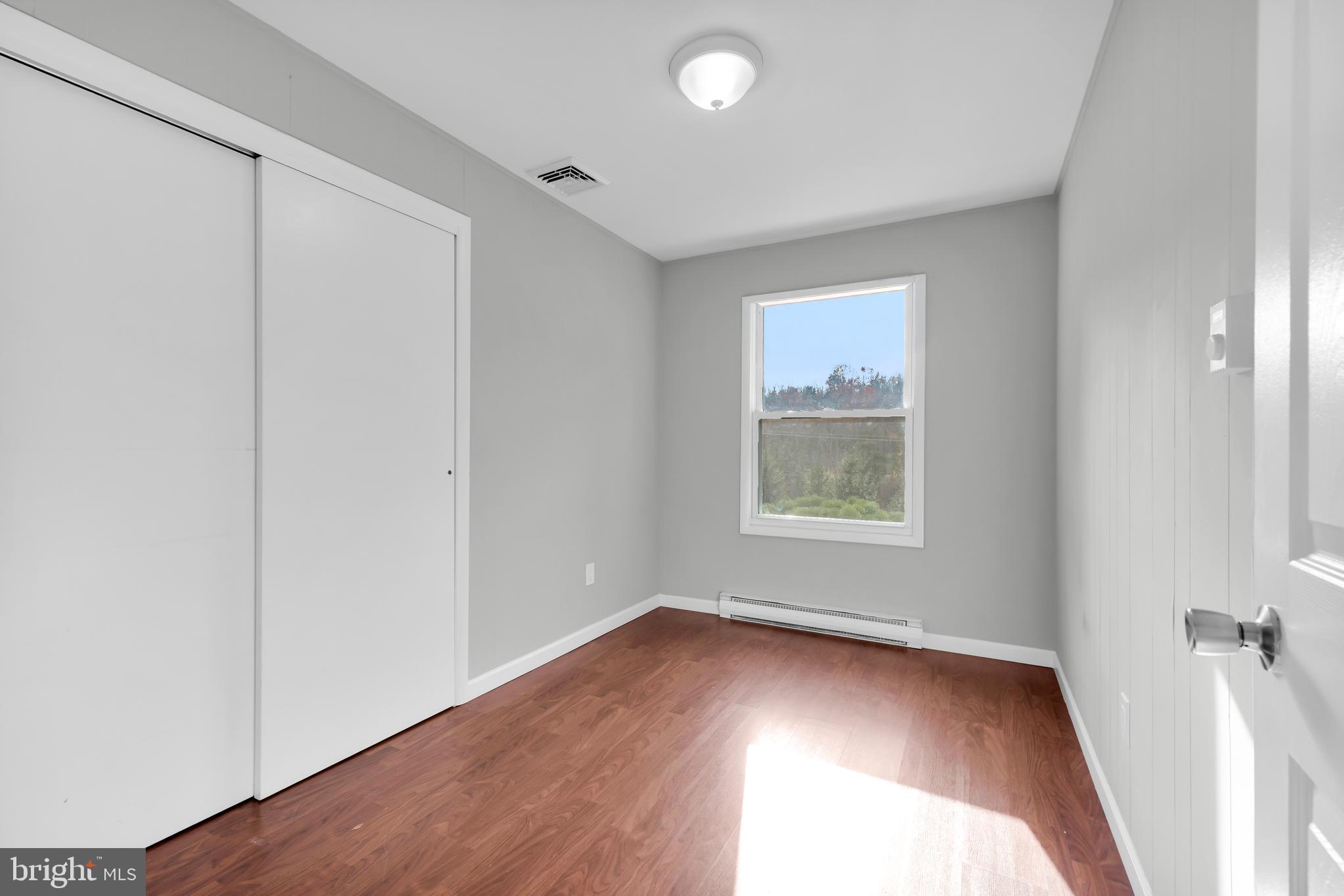 8979 Easton Road Ottsville, PA 18942 - Photo 18 of 39 an empty room with wooden floor and windows