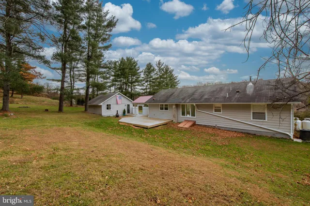 a view of a house with a yard and a large tree