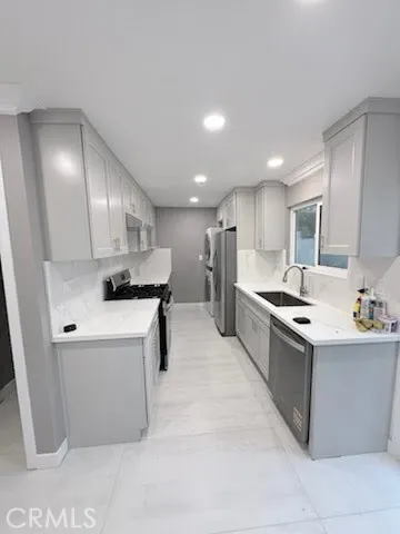 a kitchen with stainless steel appliances kitchen island granite countertop a sink and a refrigerator