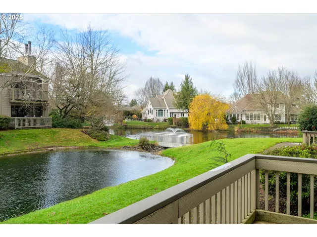 a front view of a house with a yard and lake view