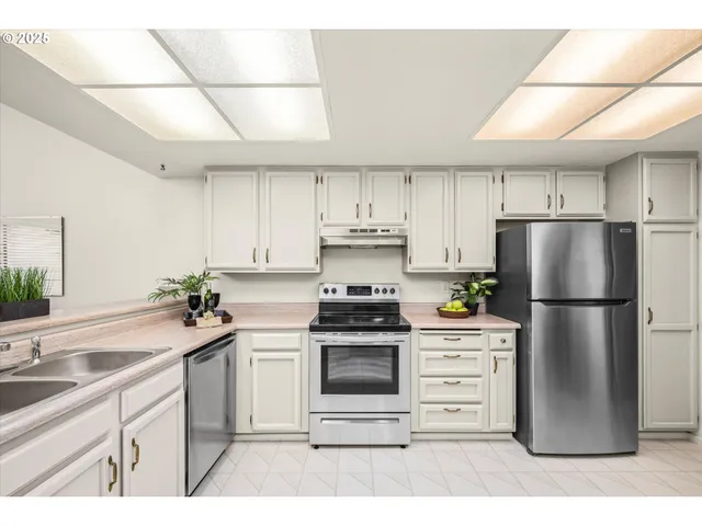 a kitchen with cabinets appliances a sink and a window
