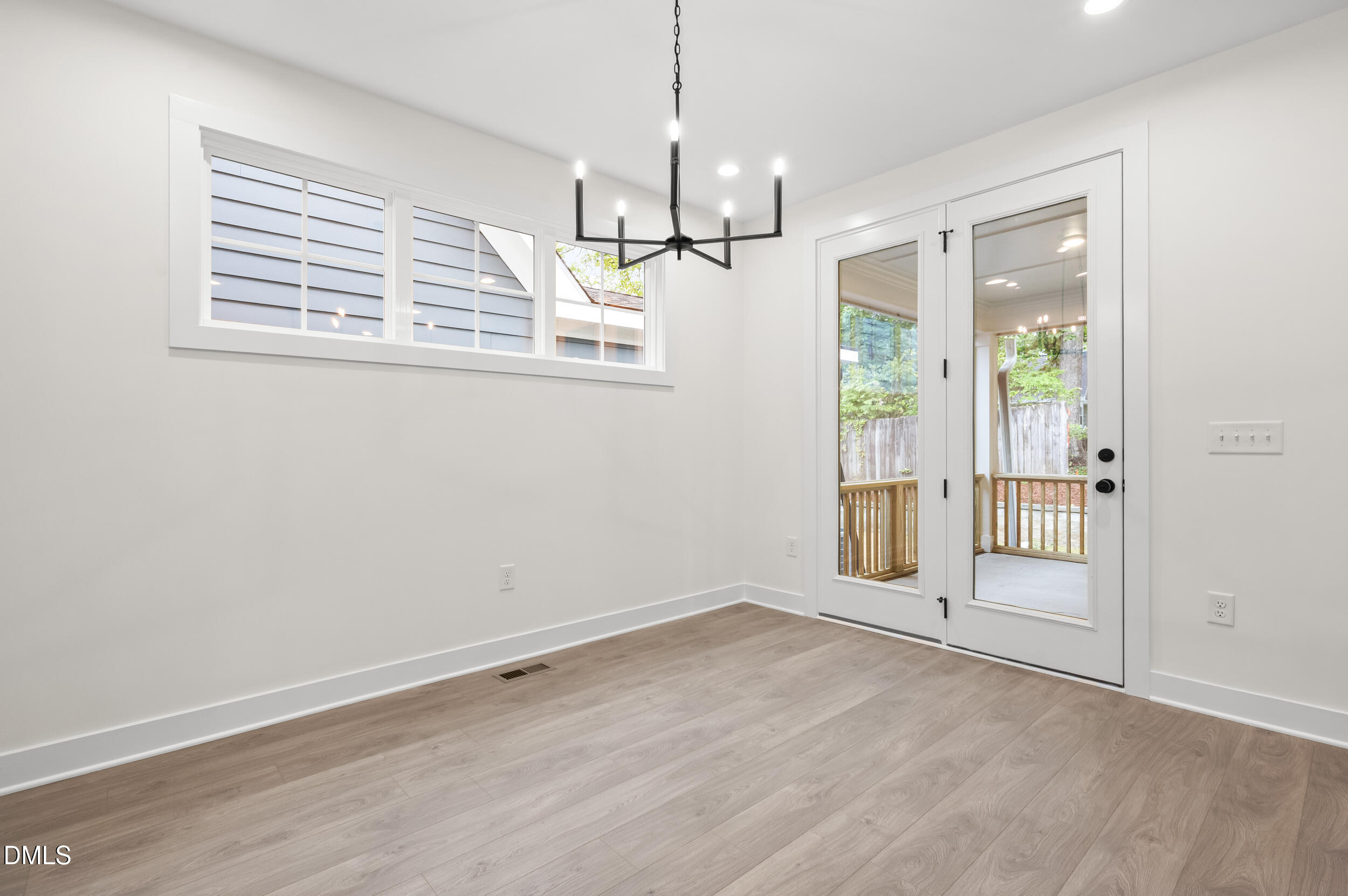 708 Grayhaven Place Raleigh, NC 27606 - Photo 7 of 33 an empty room with wooden floor and windows