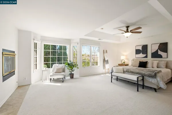 a spacious bedroom with a bed and a ceiling fan