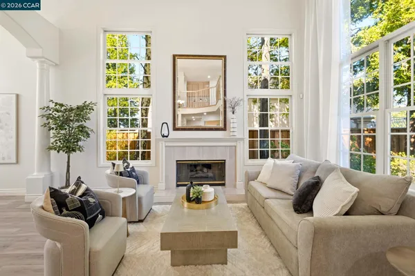 a living room with furniture a fireplace and a chandelier