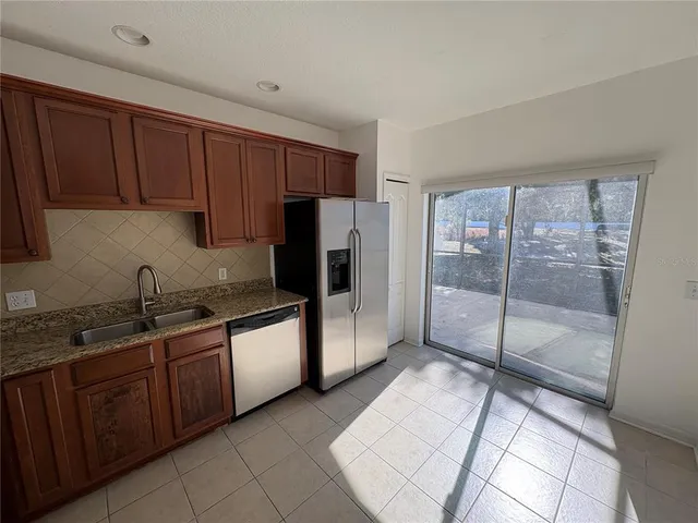 a kitchen with stainless steel appliances granite countertop a refrigerator and a sink